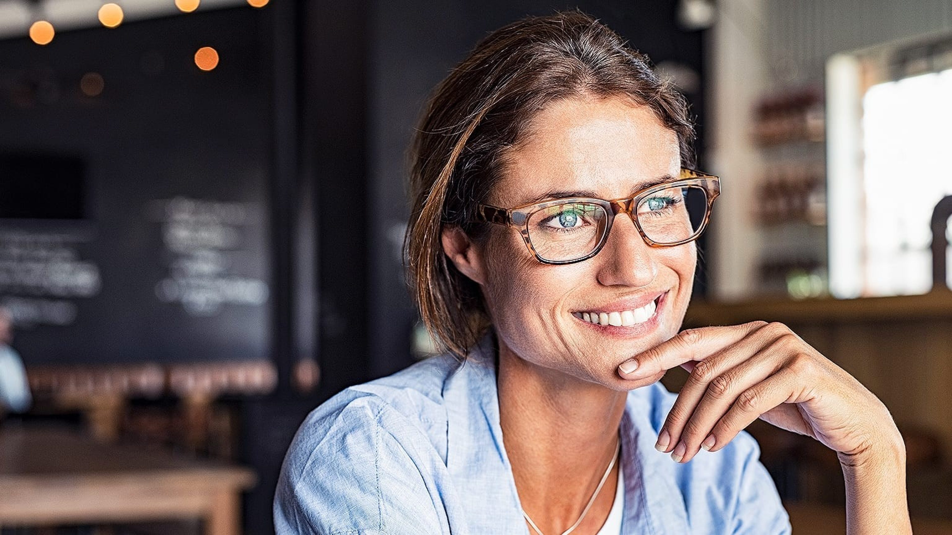 Frau mit Brille sitzt im Café