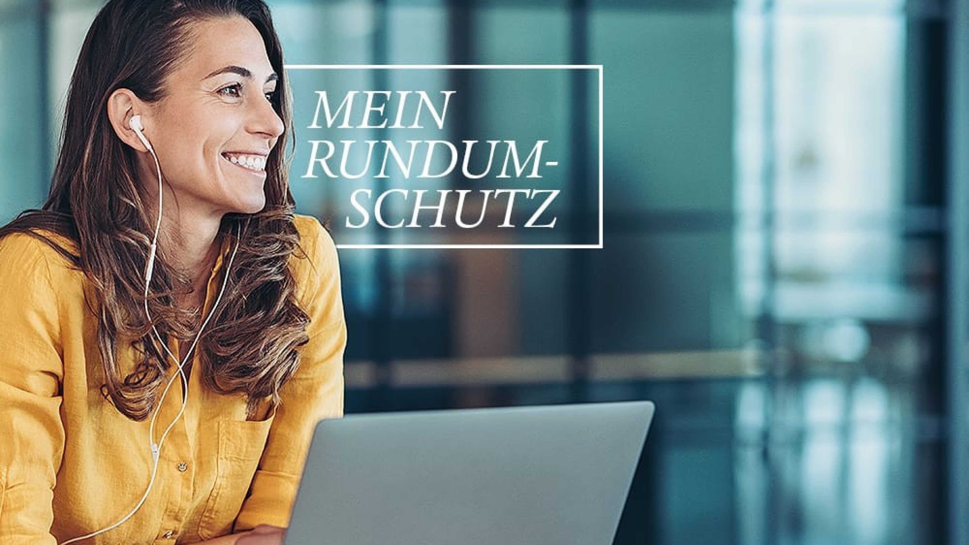 Frau mit Kopfhörer sitzt vor Laptop