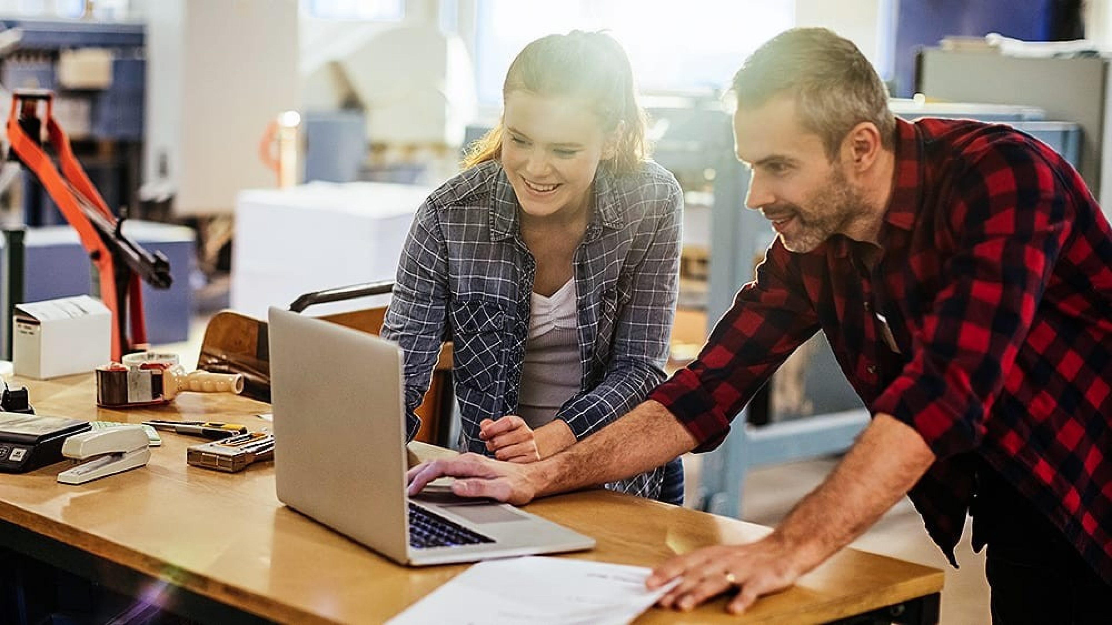 Frau und Mann vor Notebook in Werkstatt