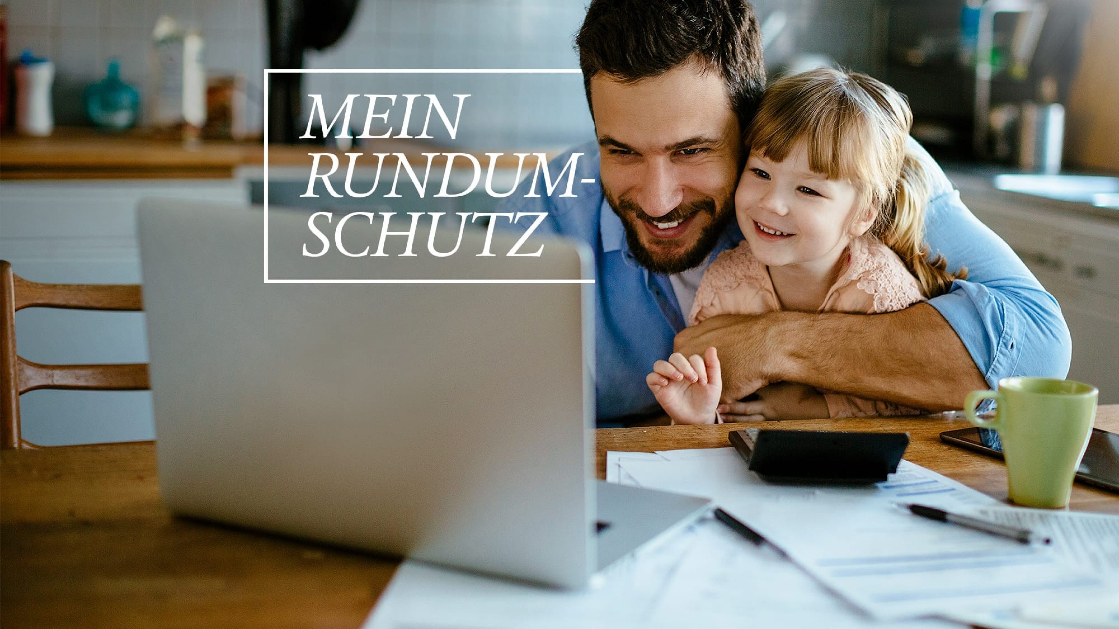 Vater und Tochter sitzen vor Laptop