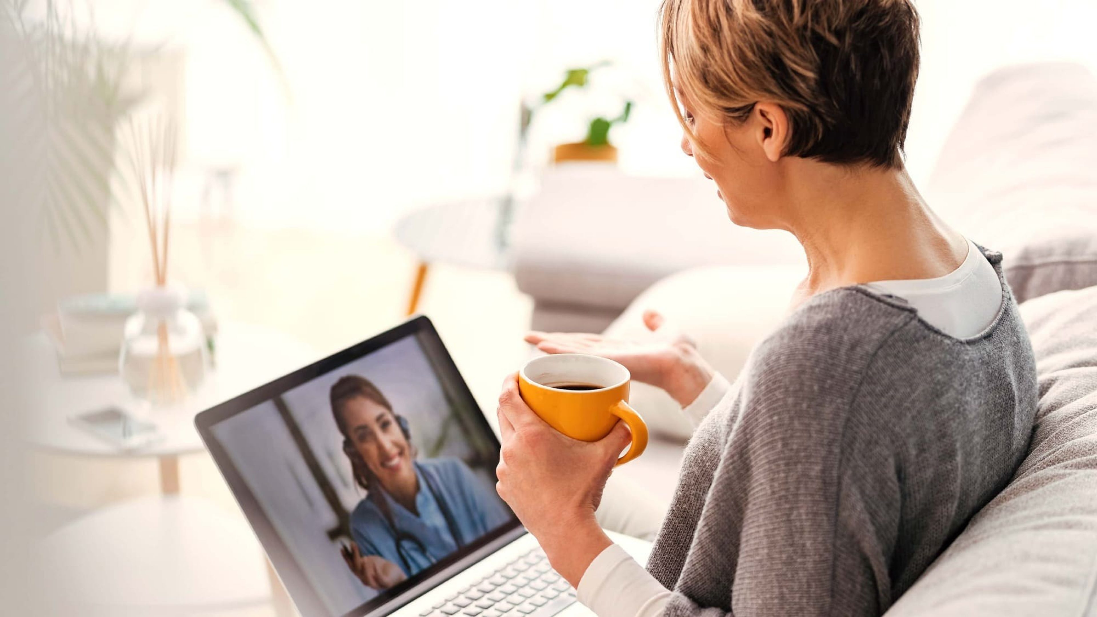 Frau mit Kaffee in Videokonferenz