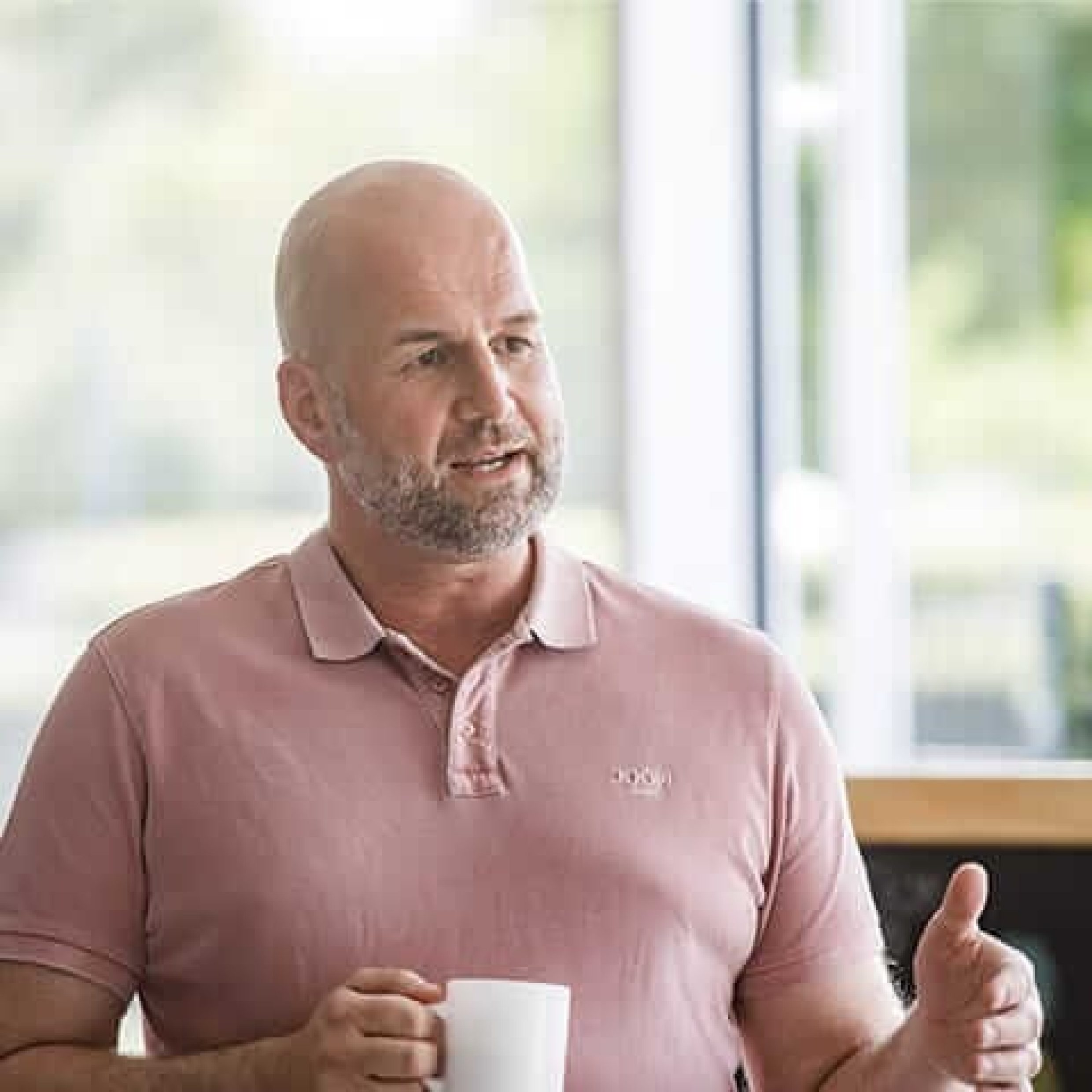 Humans of Responsibility: David Evers erklärnd mit Kaffee in der Hand