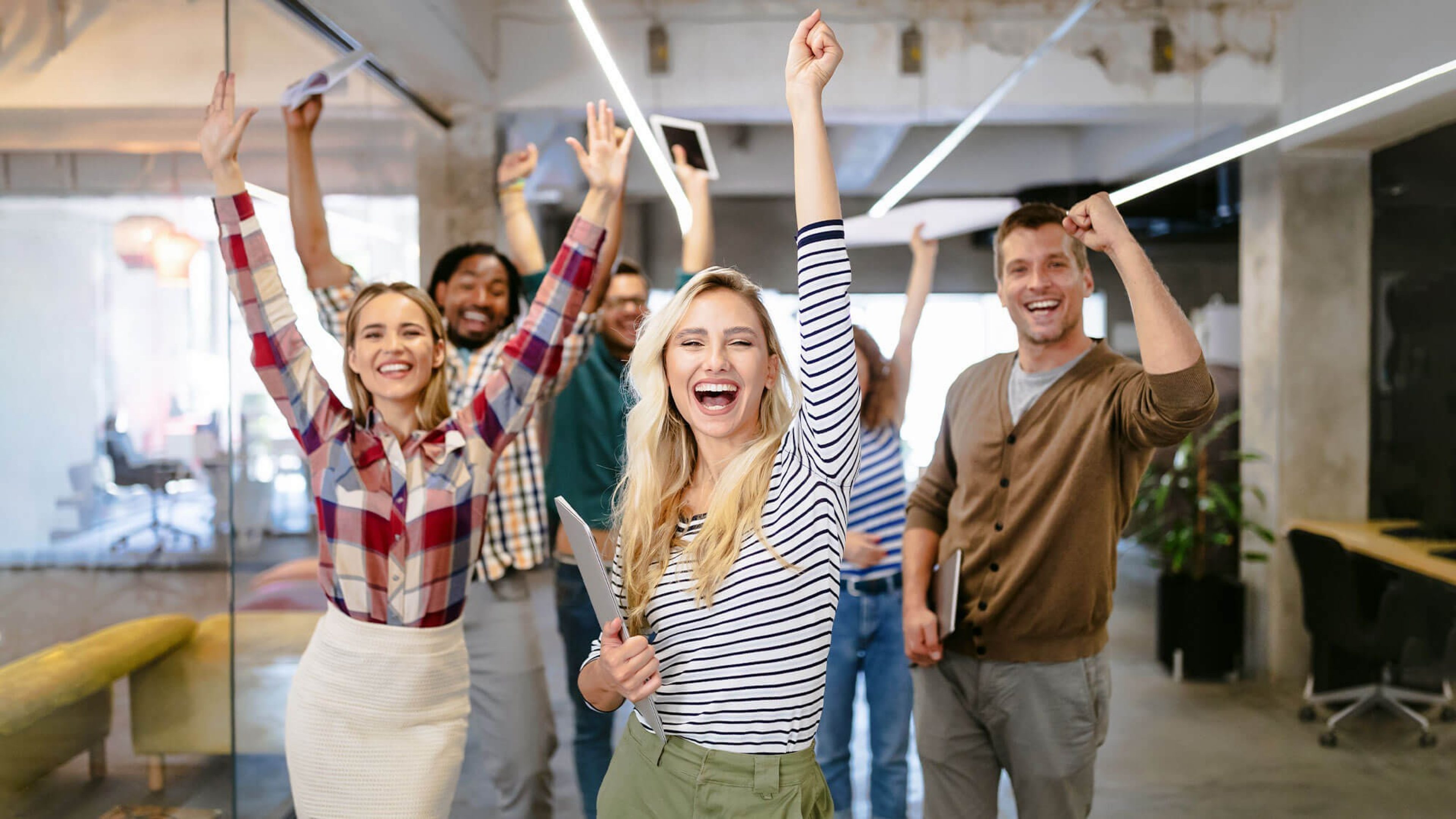 Fröhliche Büro-Mitarbeitende, die Erfolg feiern