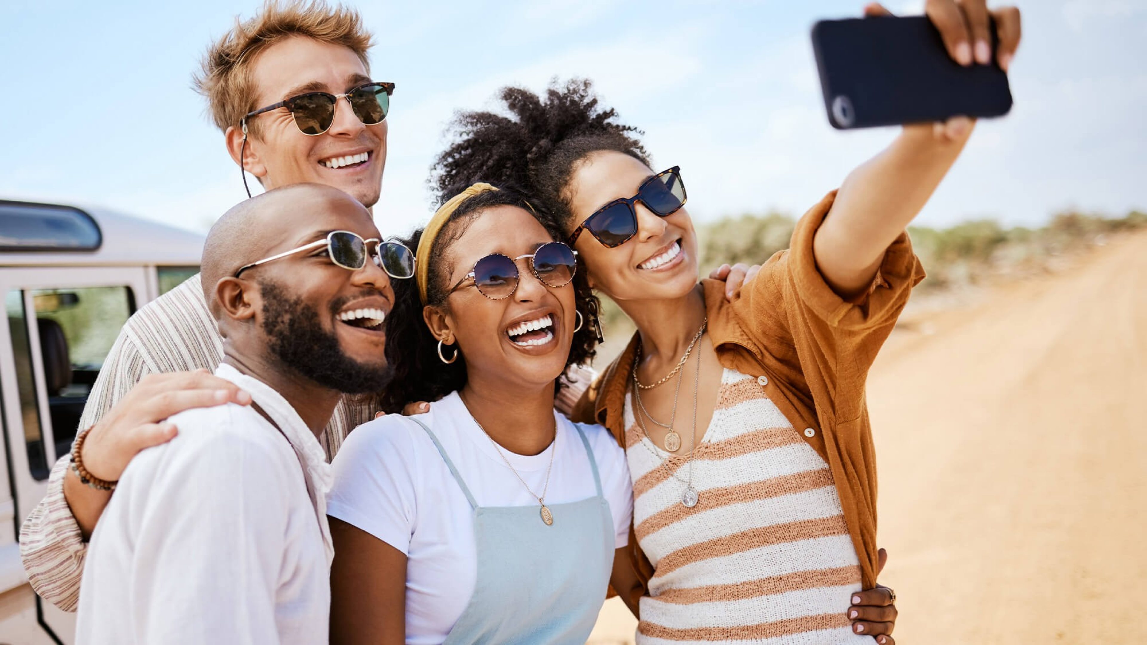 Zwei Frauen und zwei Männer machen auf Safari ein Selfie