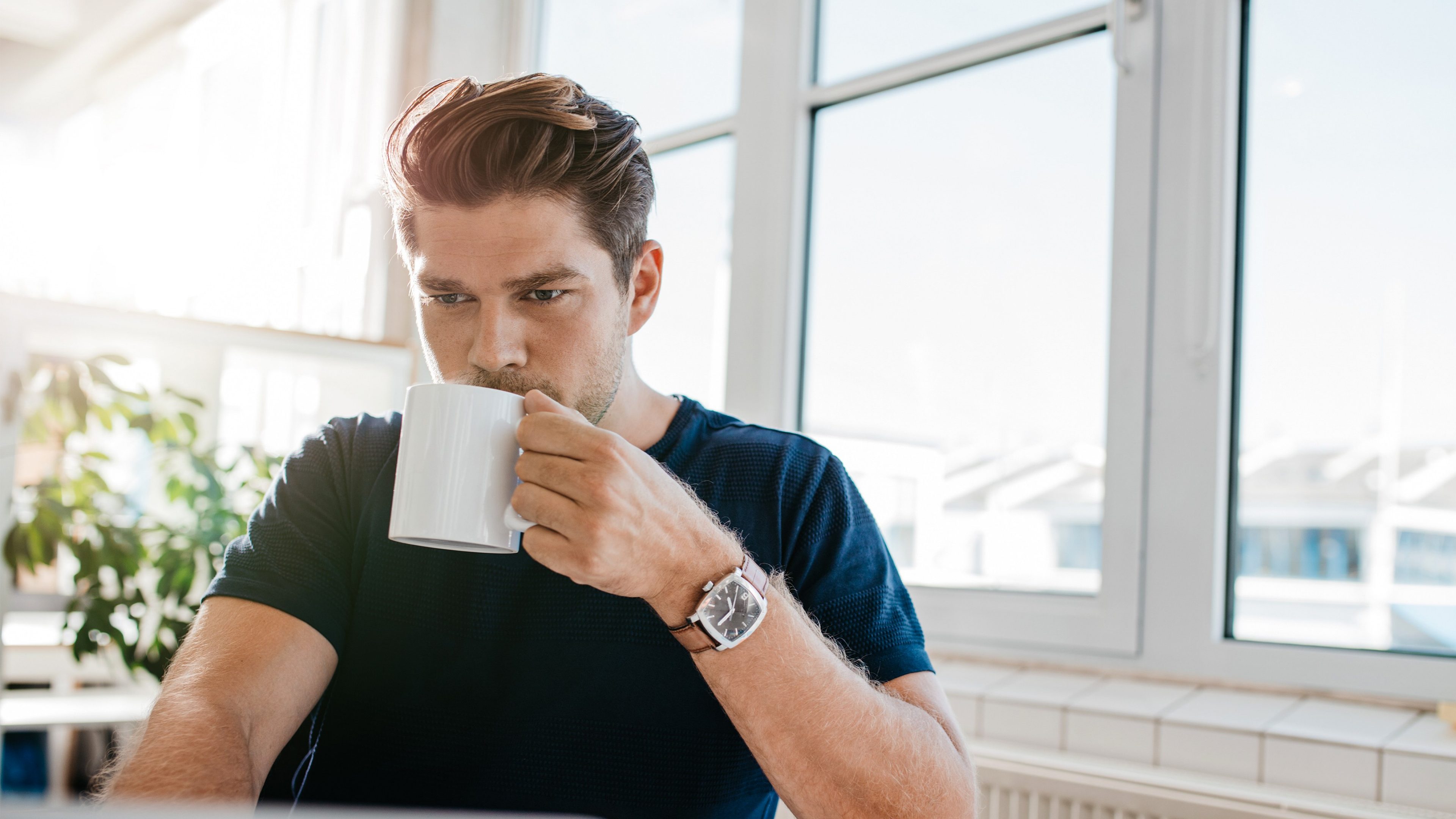 Mann trinkt aus einer Tasse