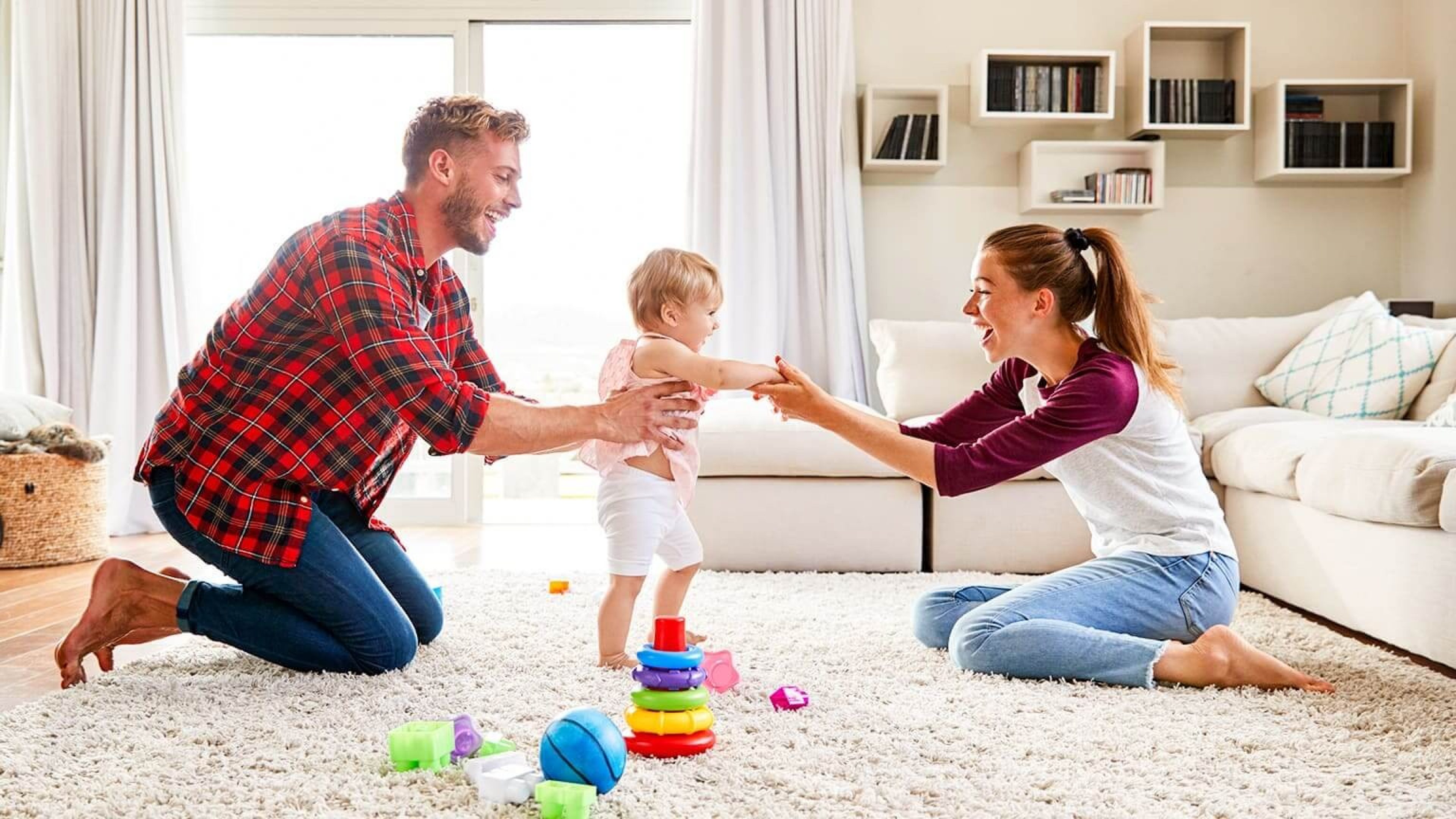 Junge Familie spielt zusammen im Wohnzimmer