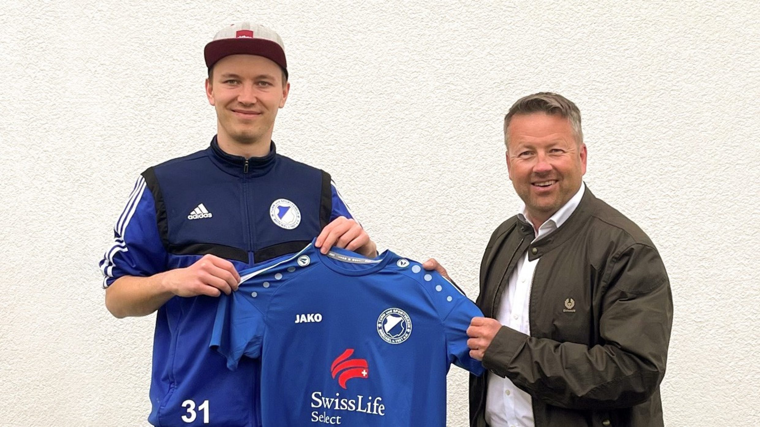 Finanzberater Jörg Krüger und Fußballspieler halten Trikot mit Swiss Life Select Logo in die Kamera